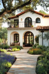 Elegant curved archway entrance of contemporary Spanish style house with large arched window and lush garden