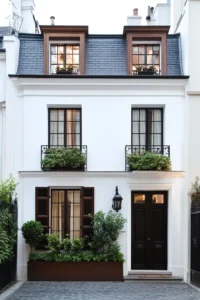 Elegant white stucco facade with rich brown window frames and forest green accents