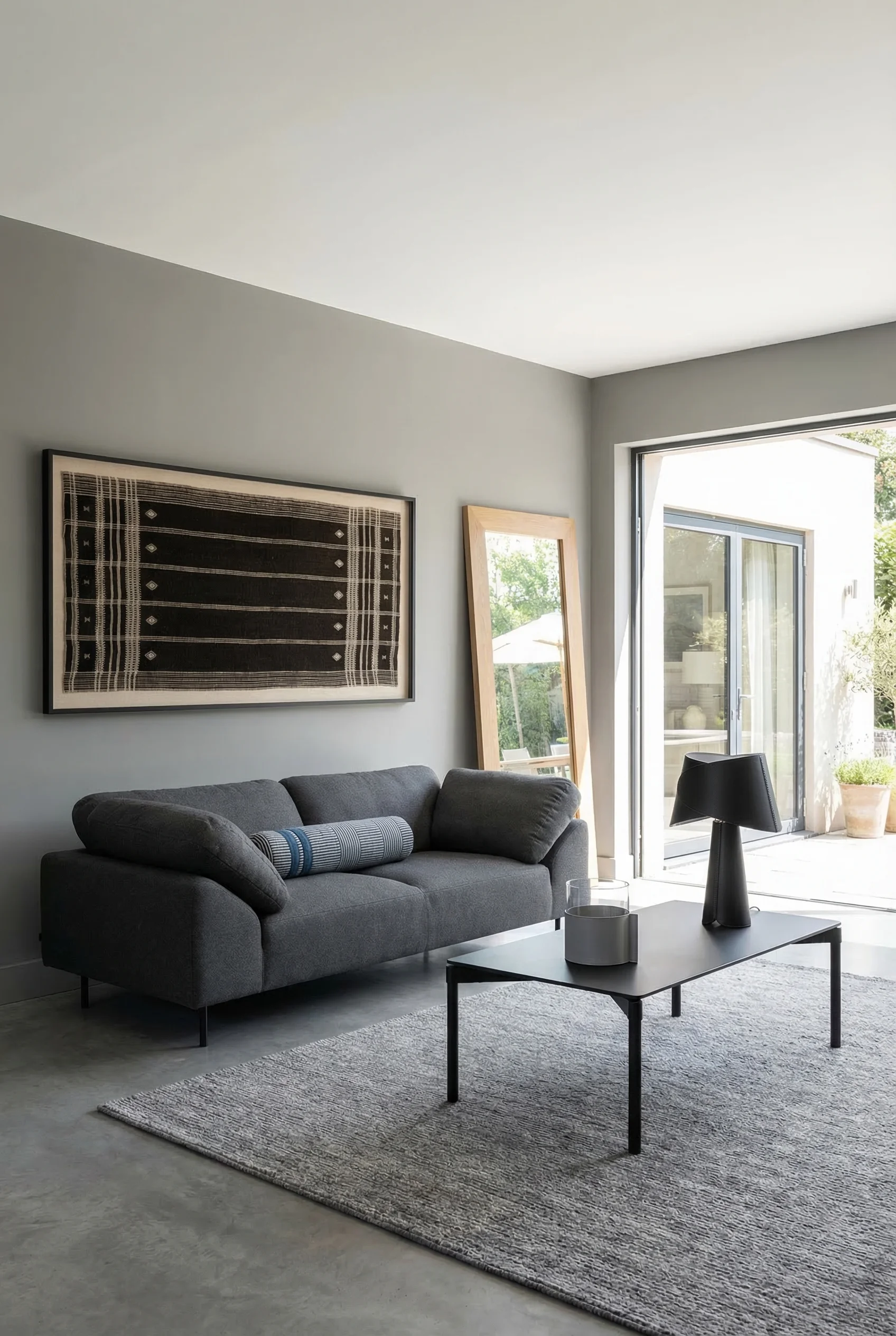 How to design a modern living room featuring gray fabric sofa with monochrome textile art