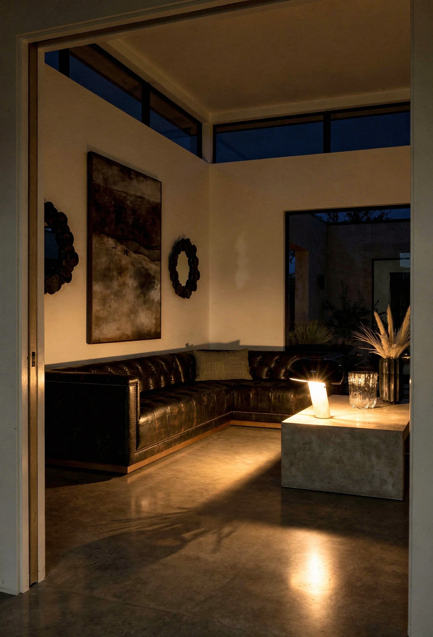 How to design a modern living room featuring black ash-framed sectional with Snoopy table lamp and gallery artwork evening mood