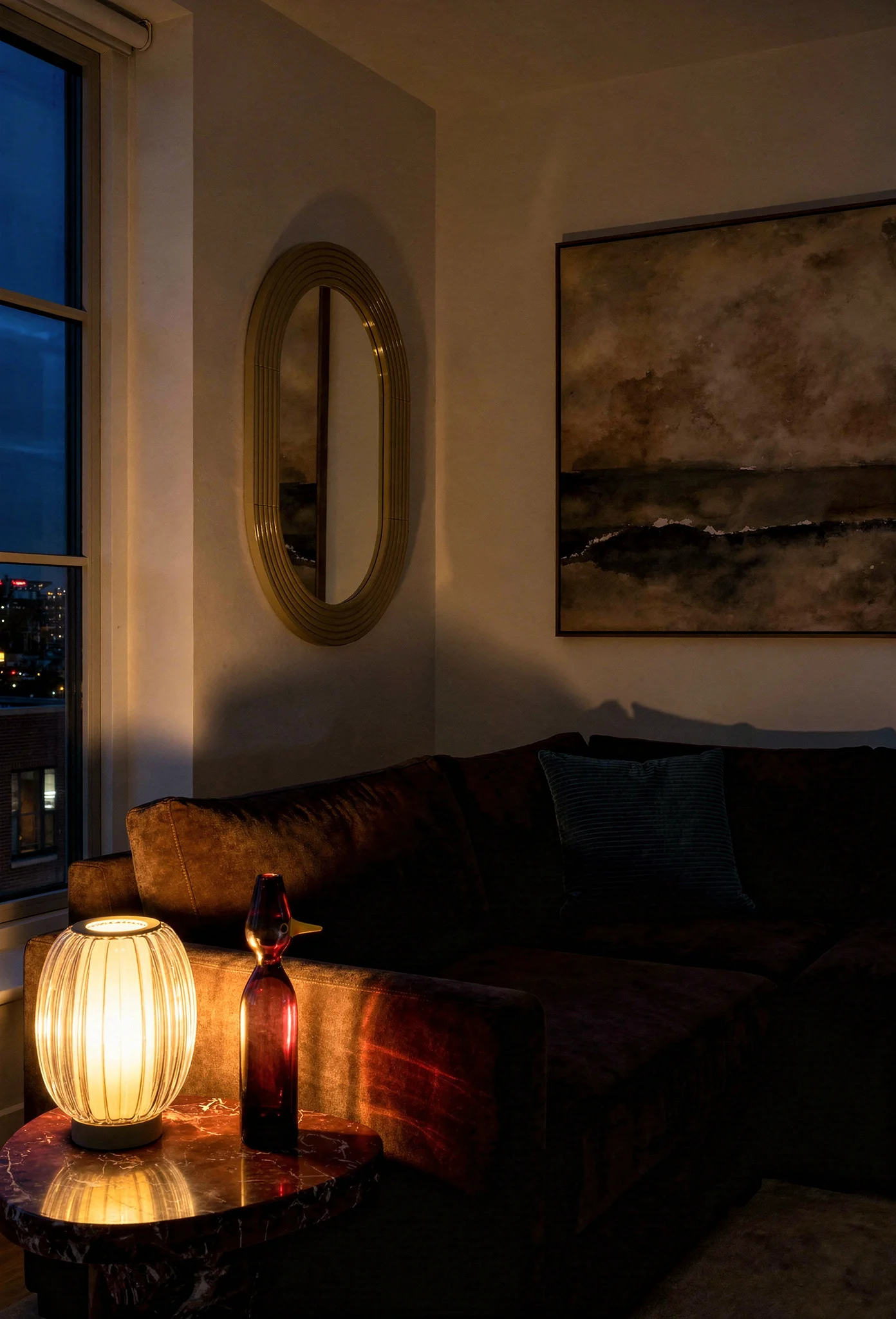 How to design a modern living room featuring brown fabric sectional with marble end table and ocean abstract art evening mood