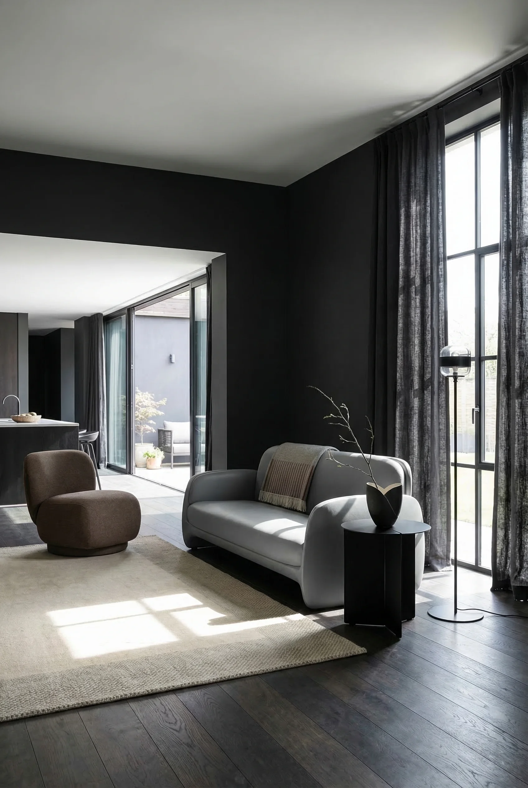 How to design a modern living room featuring gray sculptural sofa with charcoal walls and brown lounge chair