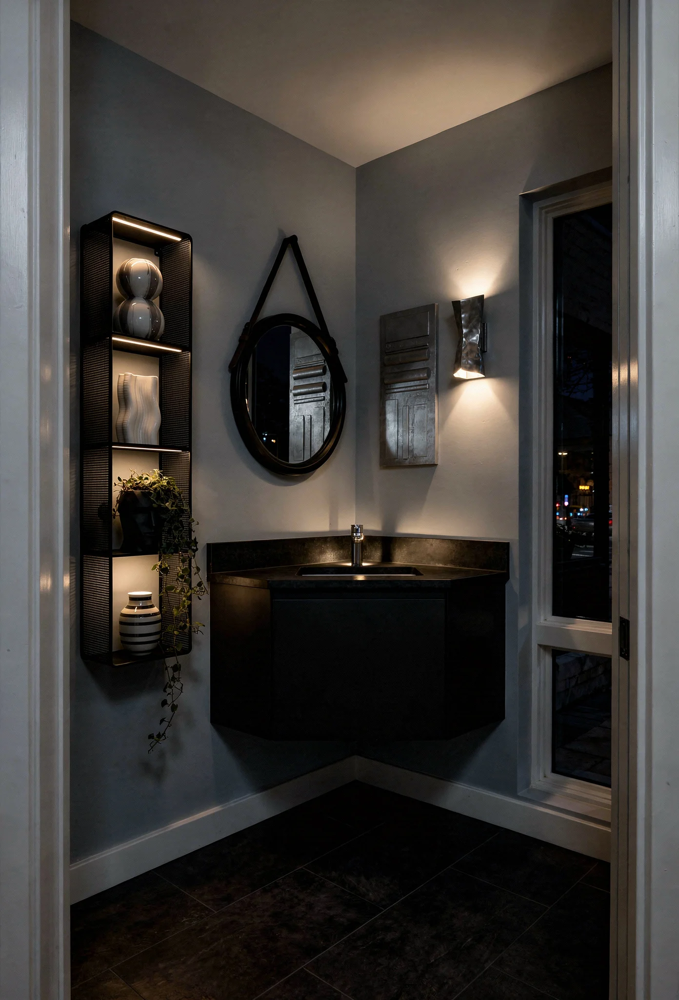 Modern small bathroom featuring black leather round mirror with corner vanity and floating black shelving evening mood