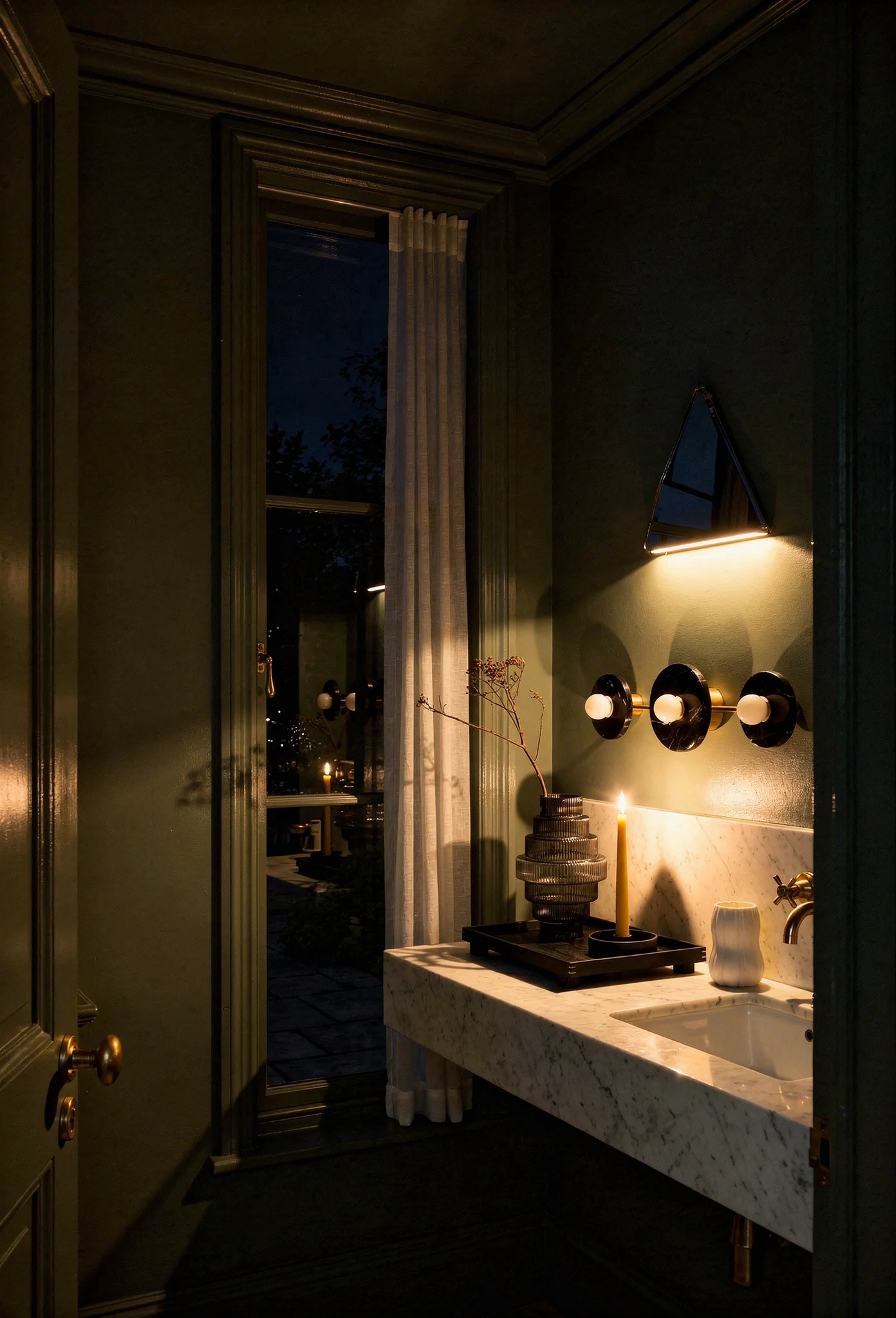Modern small bathroom featuring sculptural silver mirror with deep sage Card Room Green walls evening mood
