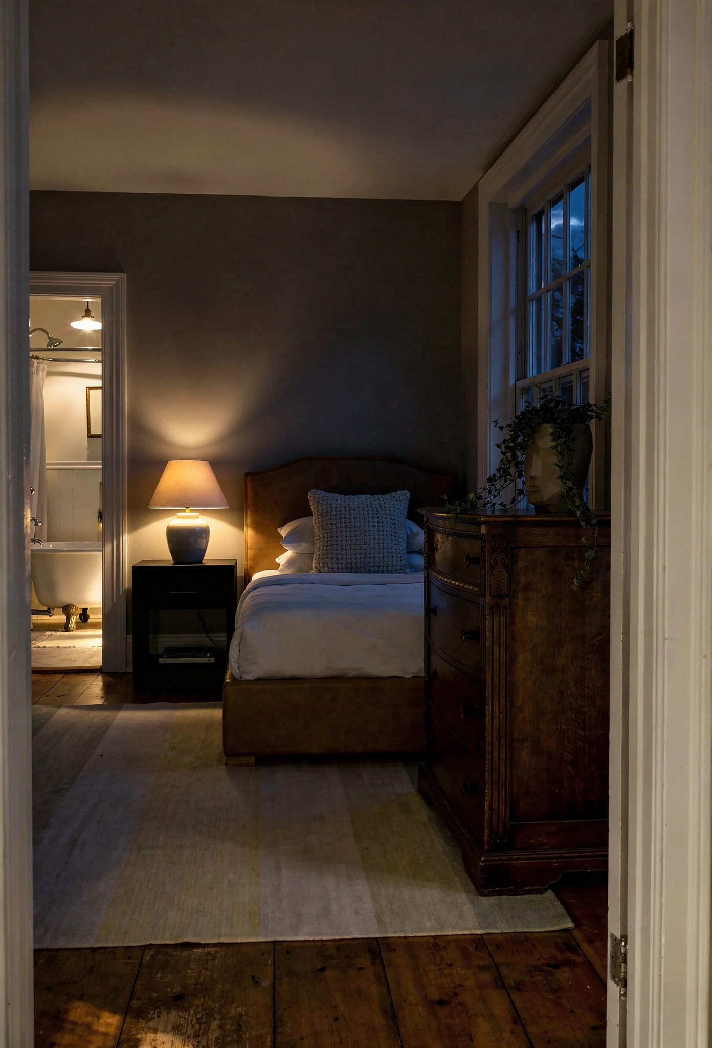 French Country Bedrooms featuring tan driftwood upholstered bed with vintage carved bombe chest of drawers evening mood