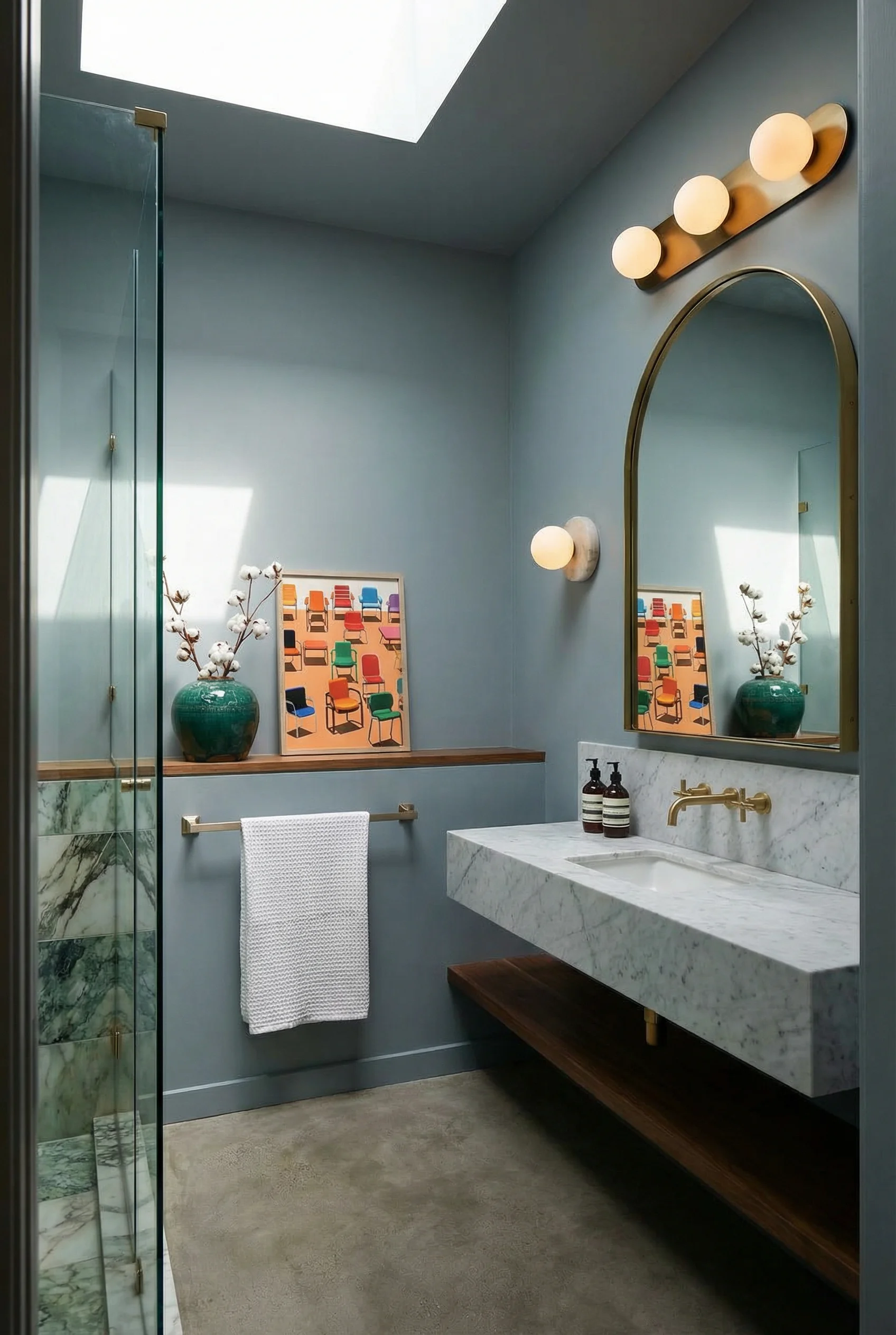 Mid Century Modern Bathroom featuring long 3-globe linear glass vanity light with marble disc wall light accent fixture