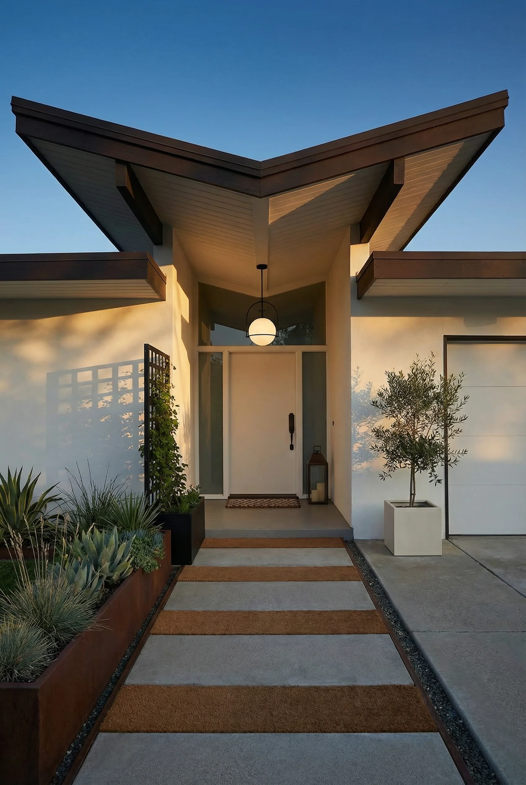 Mid century modern house exterior featuring butterfly roof with black halo pendant and bronze door handleset