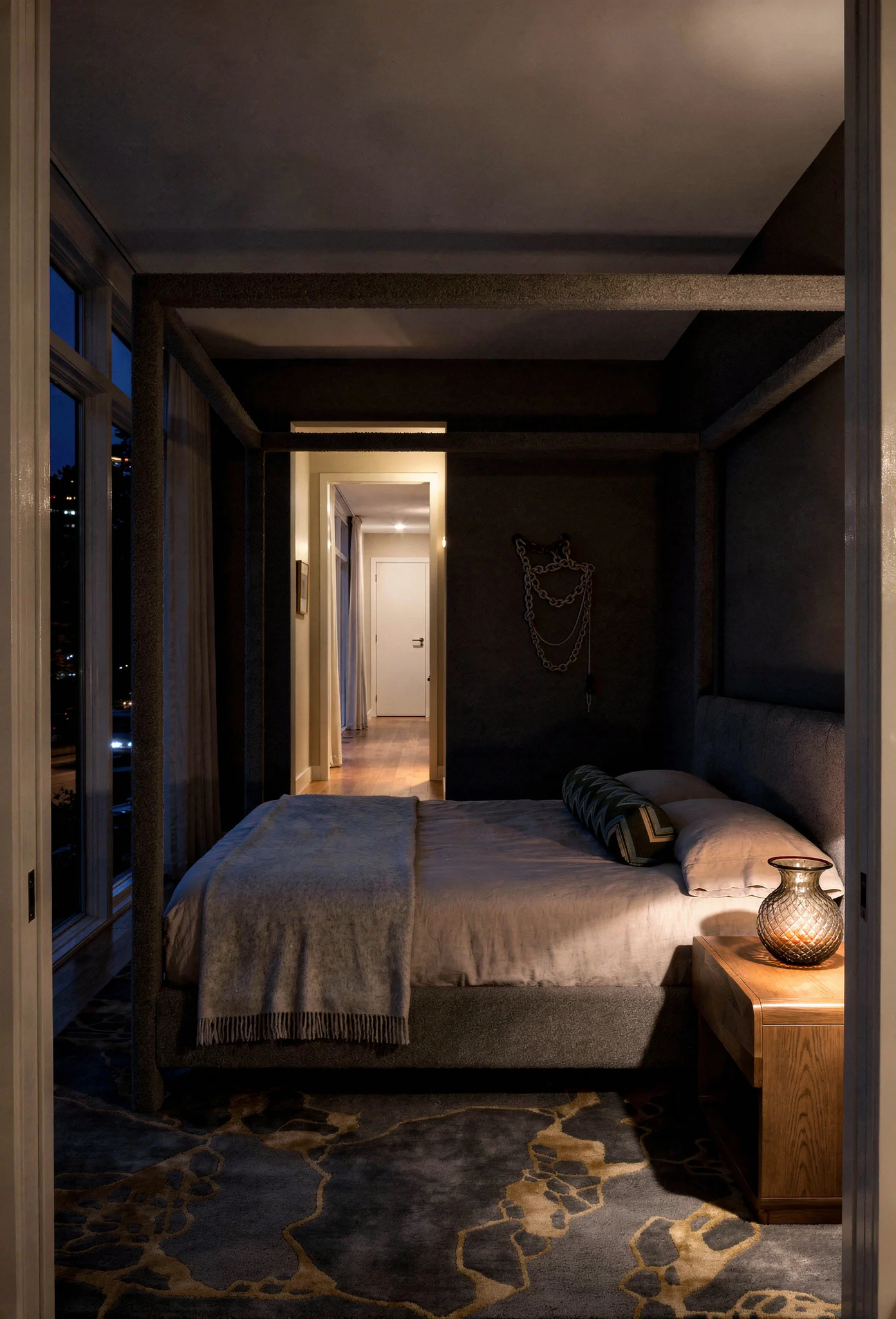 Neutral modern bedroom featuring grey boucle canopy bed with tan wool rug and textural accents evening mood