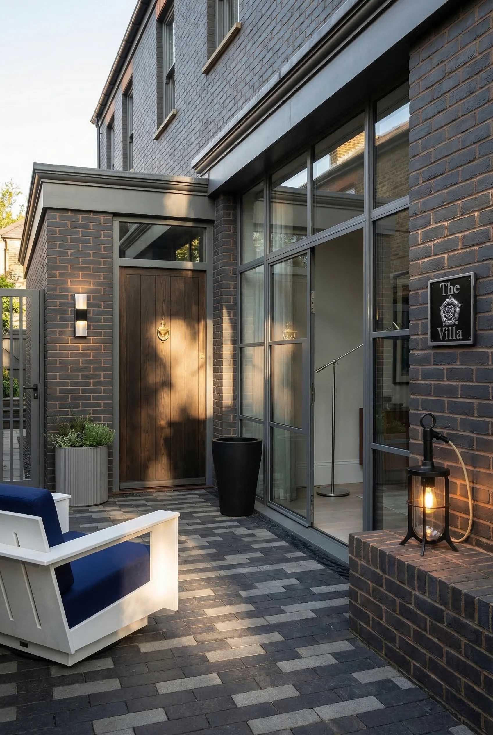Modern exterior house colors with brick featuring black silver wall sconce with gray cylinder planter