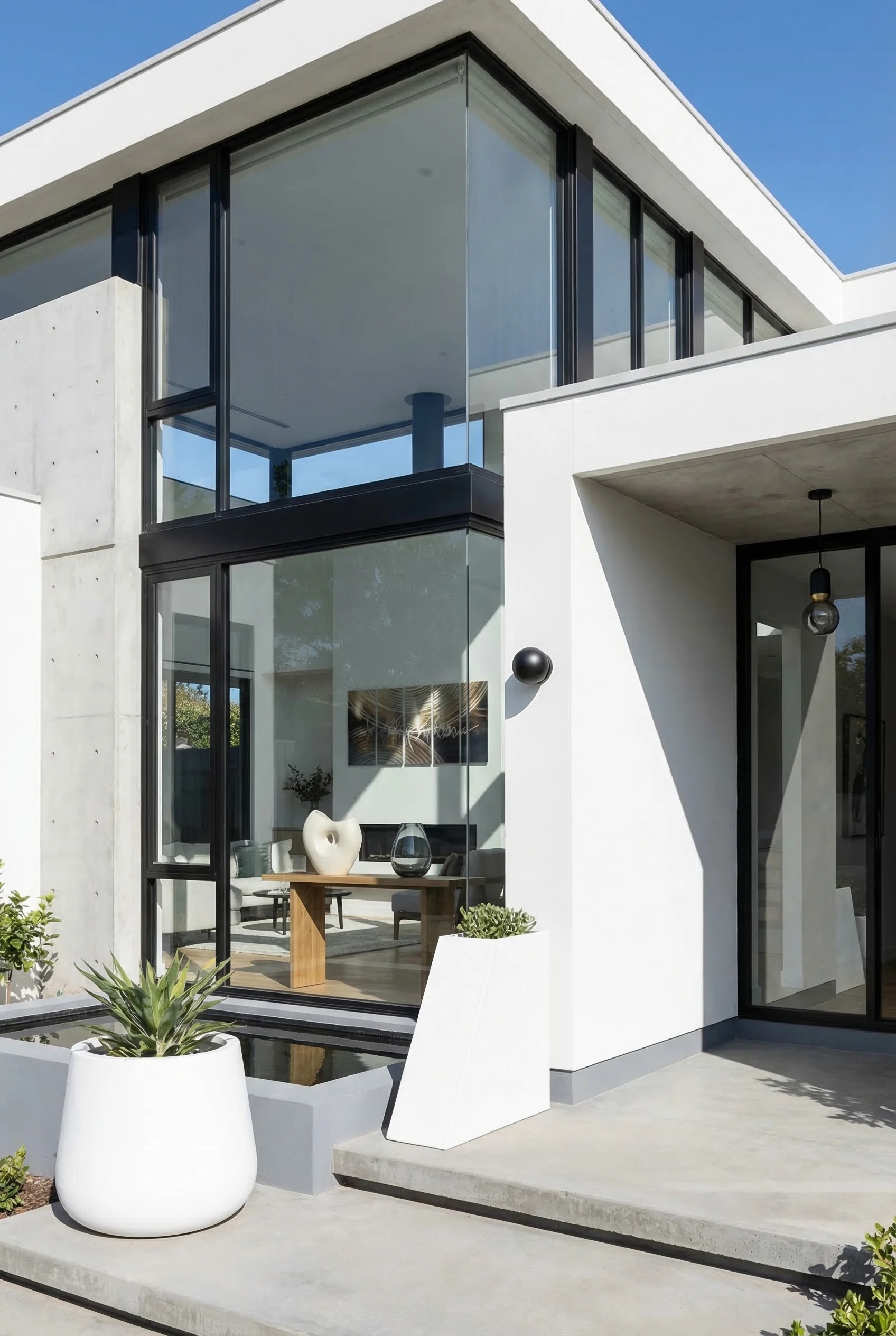 Window styles for homes exterior modern featuring black wall sconce with white planter on floor-to-ceiling glass