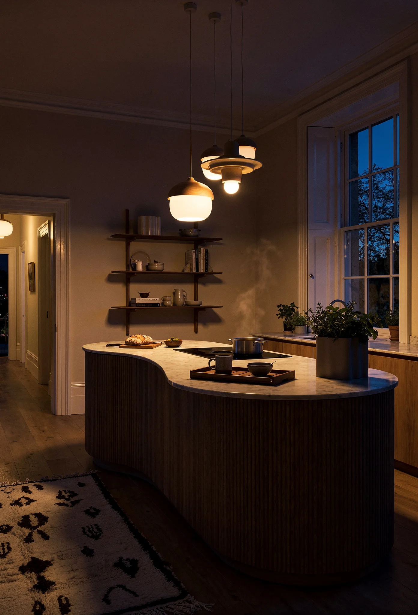 Modern kitchen featuring ivory organic wood pendant with curved oak island and cream walls evening mood