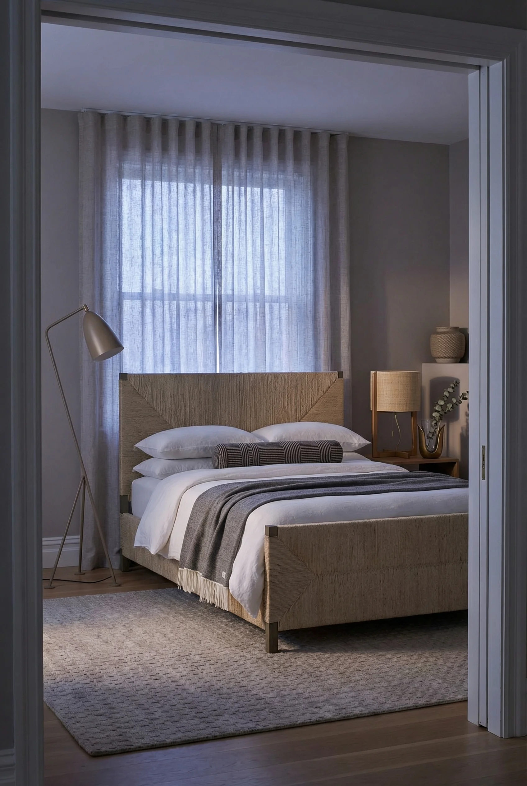 Neutral modern bedroom featuring tan woven panel bed with warm grey floor lamp