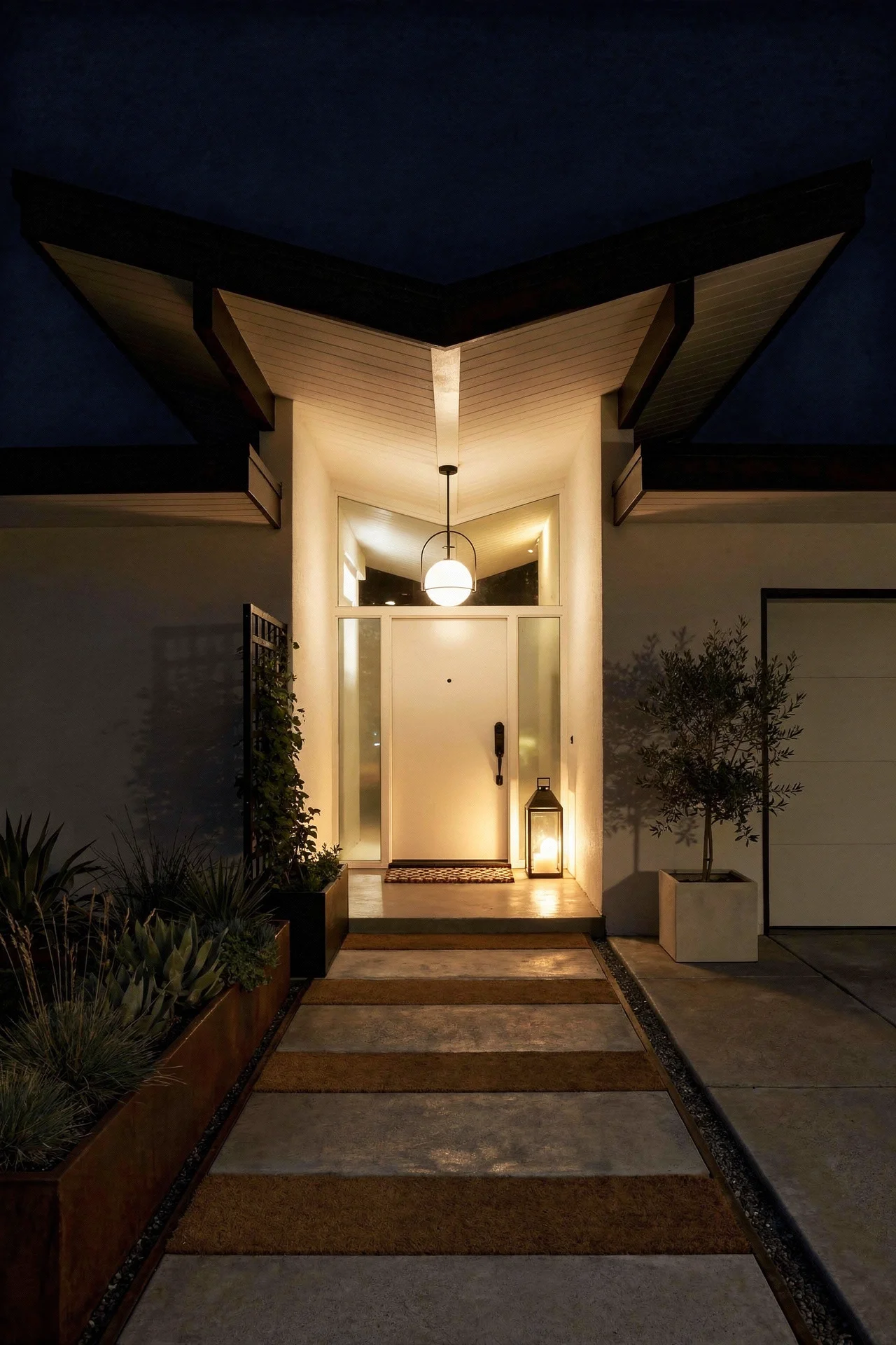 Mid century modern house exterior featuring butterfly roof with black halo pendant and bronze door handleset evening mood