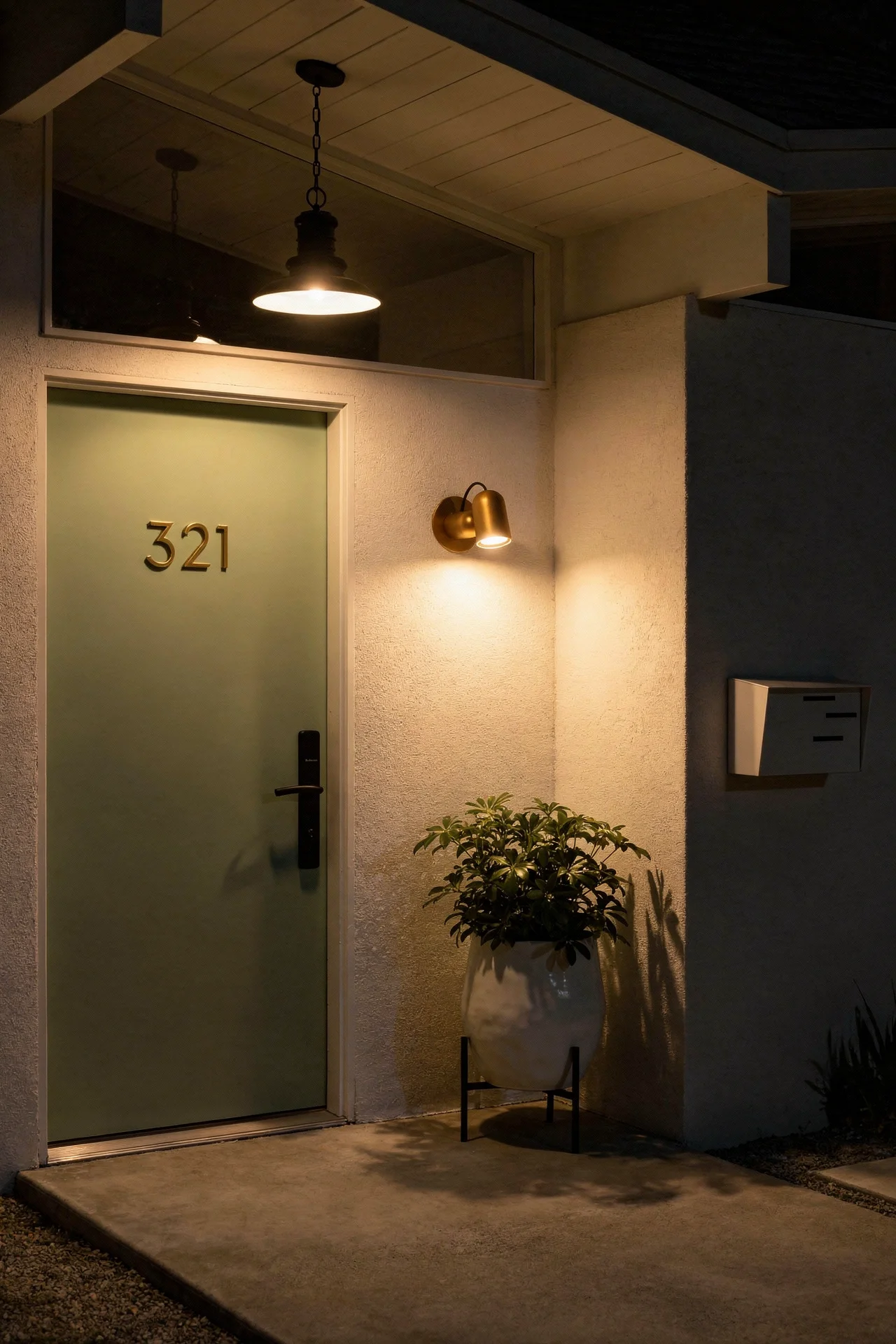 Mid century modern house exterior featuring walnut bronze wall sconce with white ceramic planter and green door evening mood