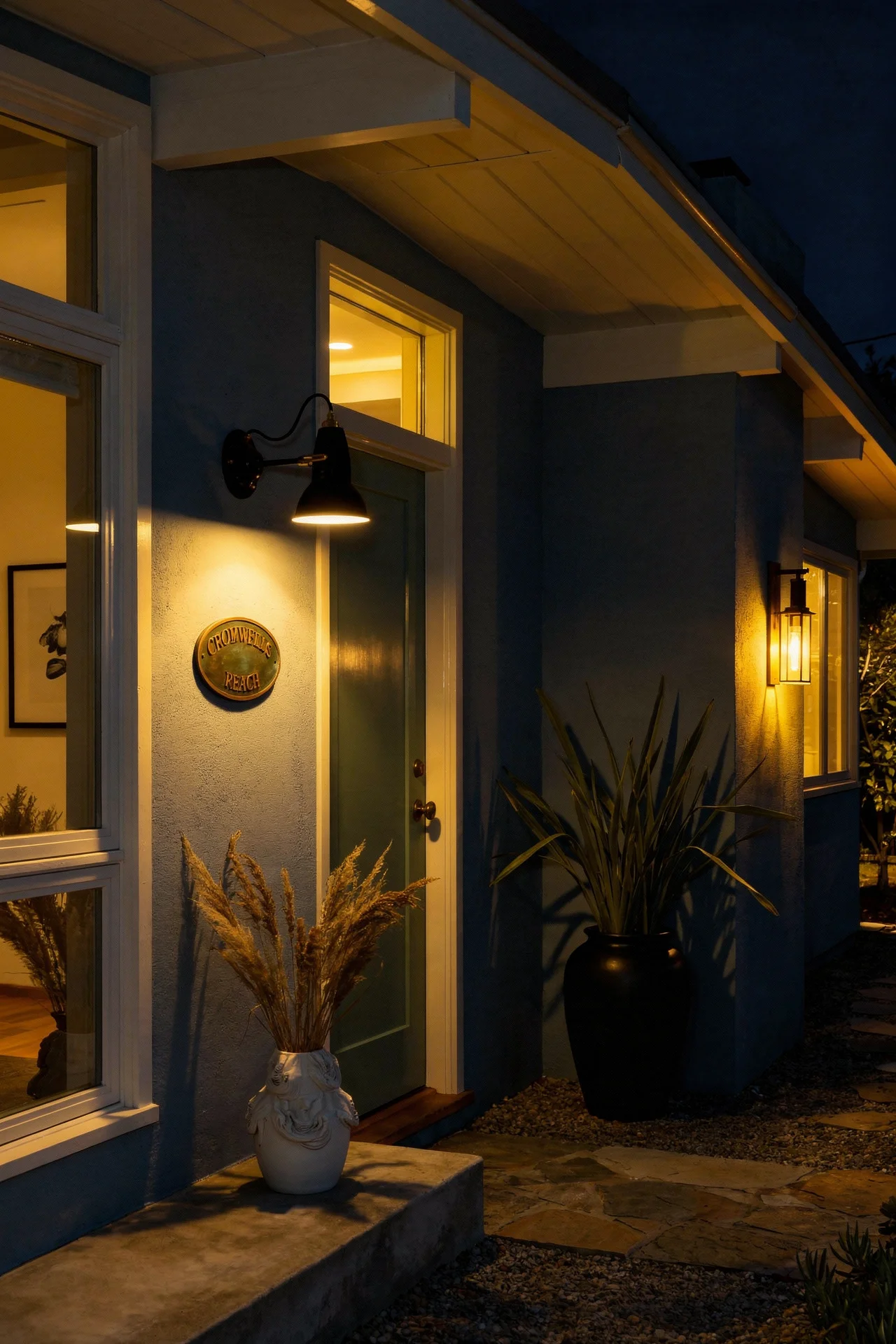 Mid century modern house exterior featuring cool blue walls with green door and brass anglepoise light evening mood
