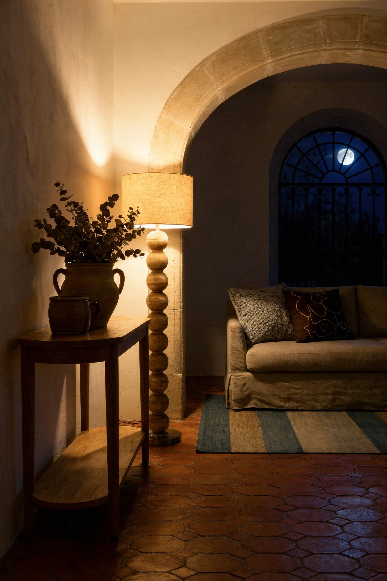 French Country Living Room featuring oak console table with terracotta hexagonal tiles and stone archway evening mood