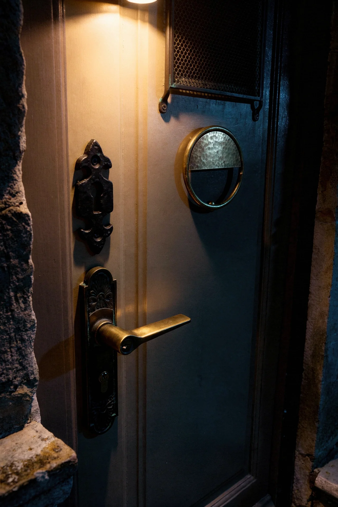 French Country Exterior evening lighting featuring bronze door hardware with warm patina detail