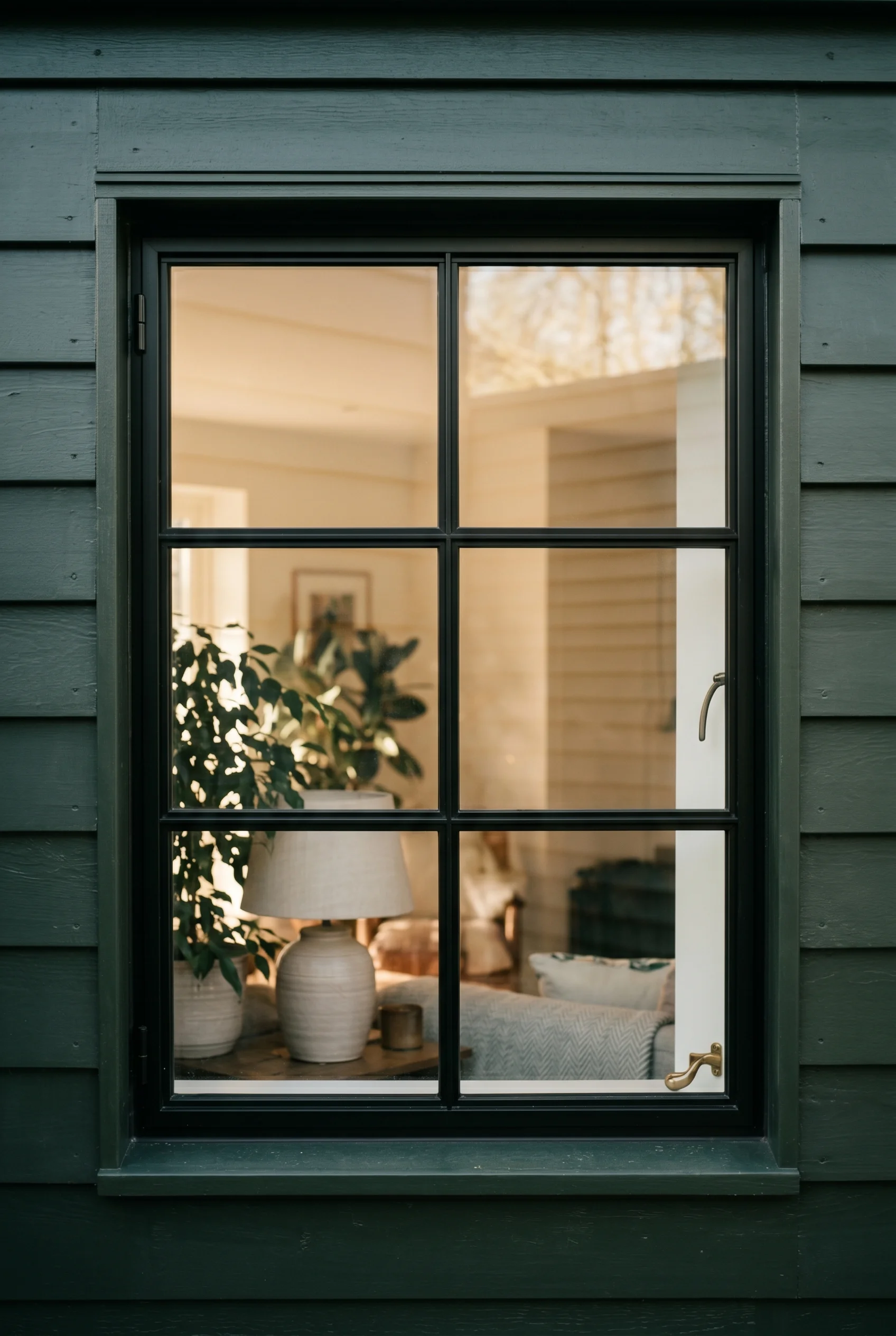 Victorian Exterior design scene against Carriage Green very dark green painted clapboard and window surround behind the black steel frame walls