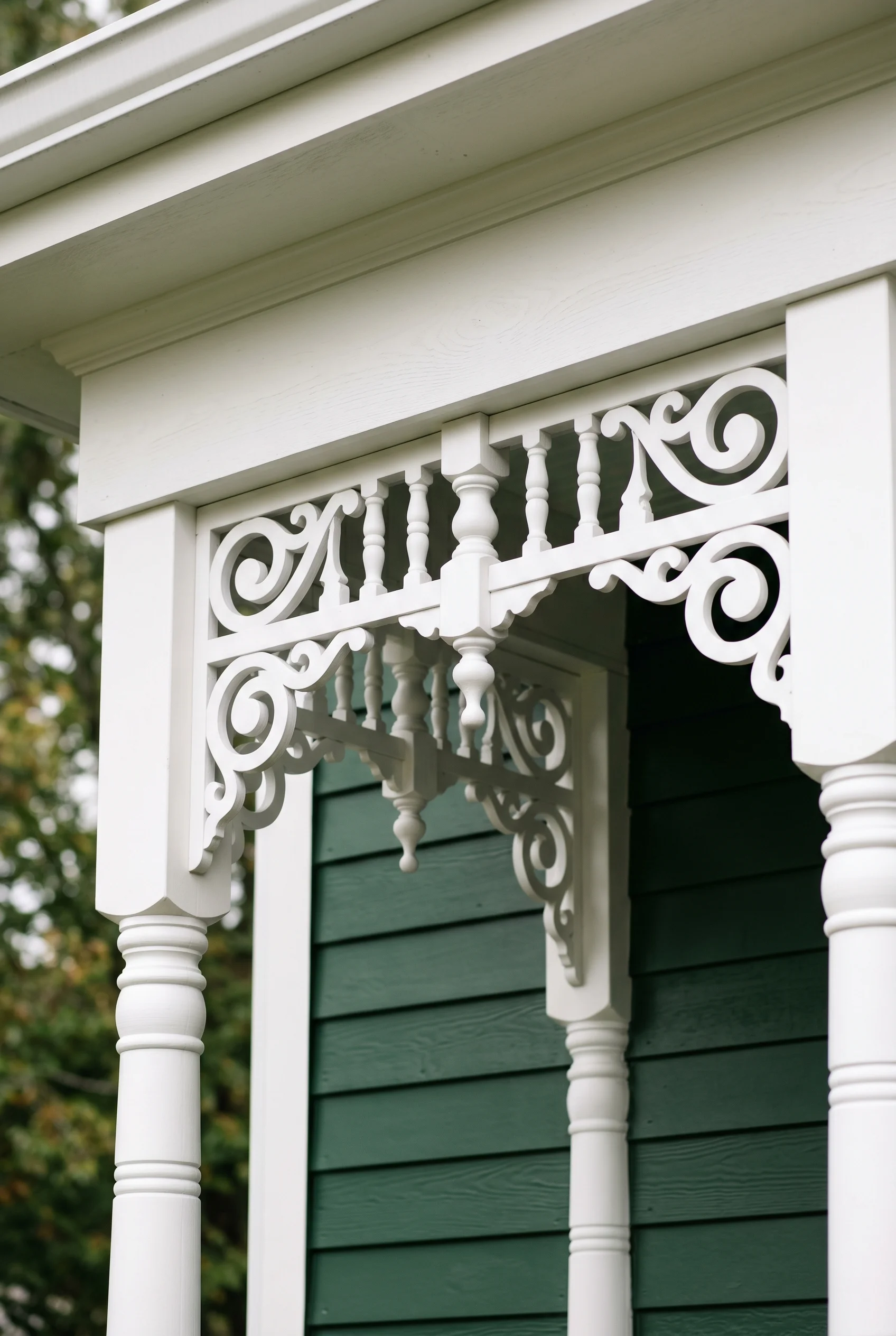 Victorian Exterior design scene against Minster Green deep forest-green clapboard siding as the backdrop behind the white PVC millwork walls
