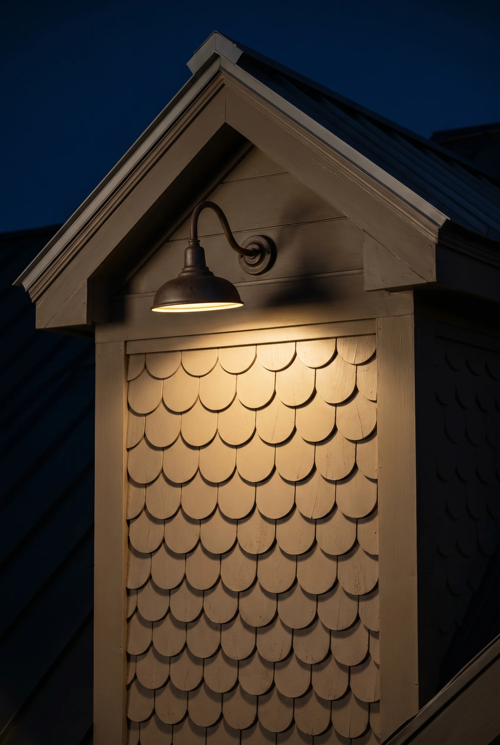 Victorian Exterior featuring gooseneck sconce against Charleston Gray warm taupe-grey painted dormer fascia board as the mounting surface behind the g