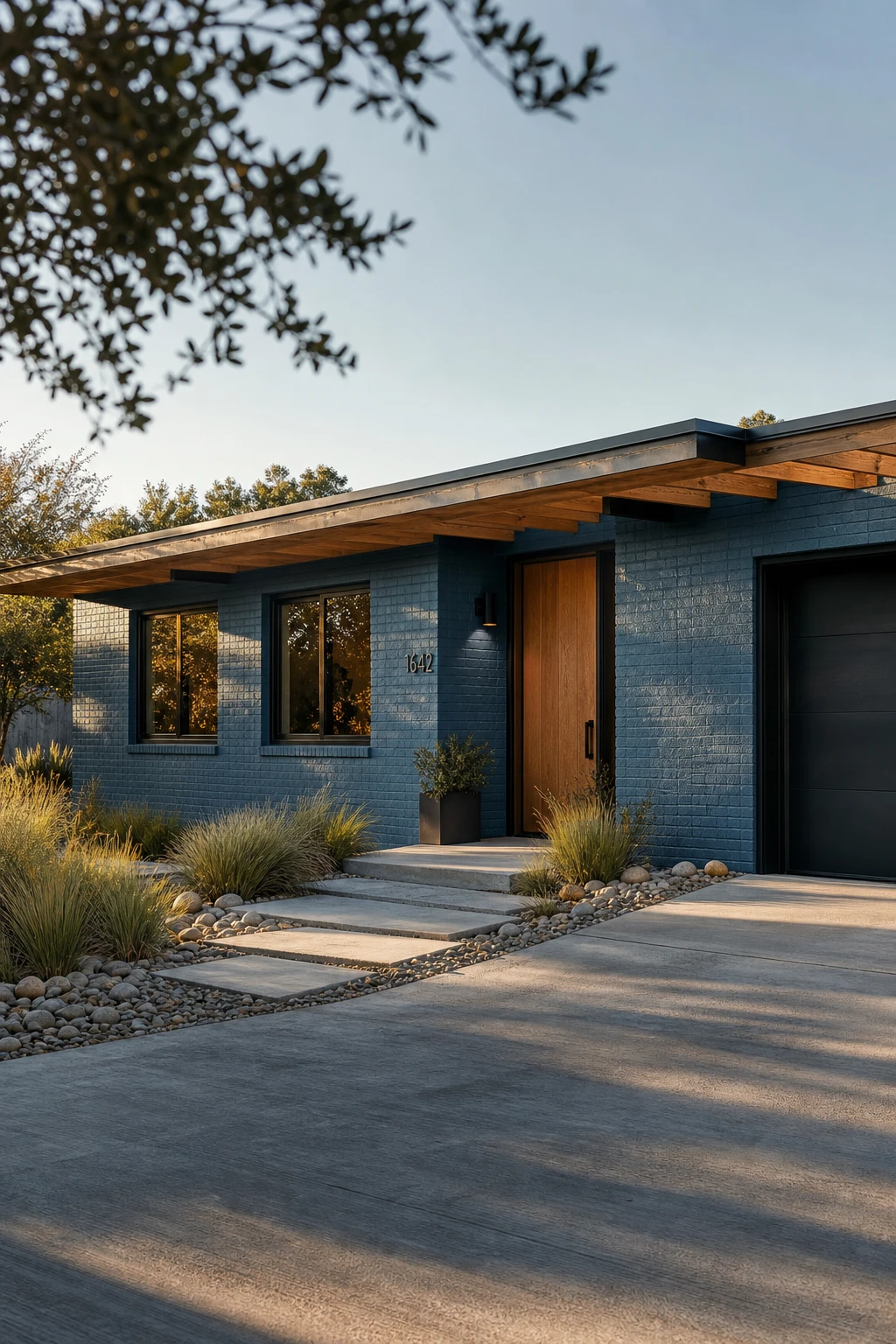 Blue Modern Ranch Exterior with painted brick facade in Farrow & Ball Stone Blue, showing rich brick texture depth, wide low roofline, and landscaped front garden in afternoon light.