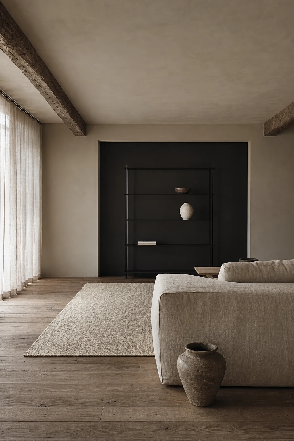 A Belgian minimalist beige and black living room with raw linen sofa, wabi sabi ceramics, aged oak floor and Farrow and Ball Off Black painted wall panel
