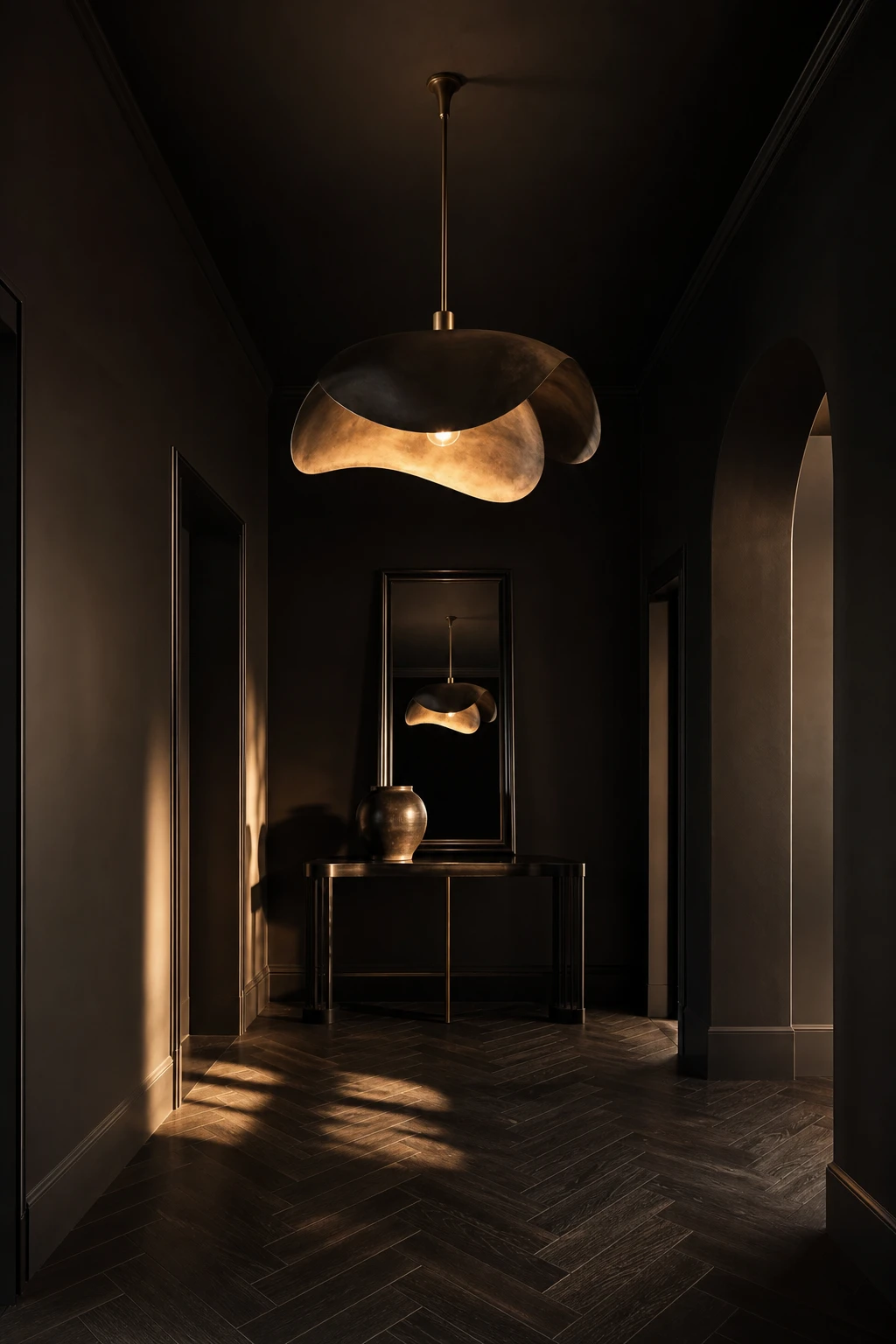 All black hallway with oversized statement pendant as hero, Farrow and Ball Tar walls, dark herringbone floor, narrow console table and black framed mirror