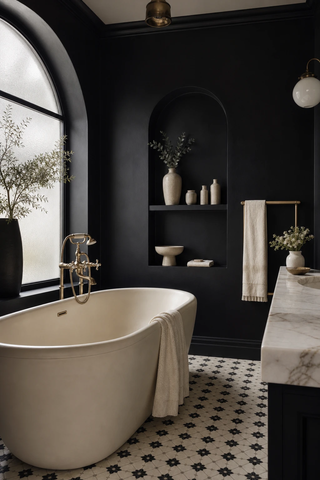 Luxurious black and cream bathroom with dramatic dark walls, cream freestanding tub, gold fixtures, mosaic floor tiles and natural light from a frosted window
