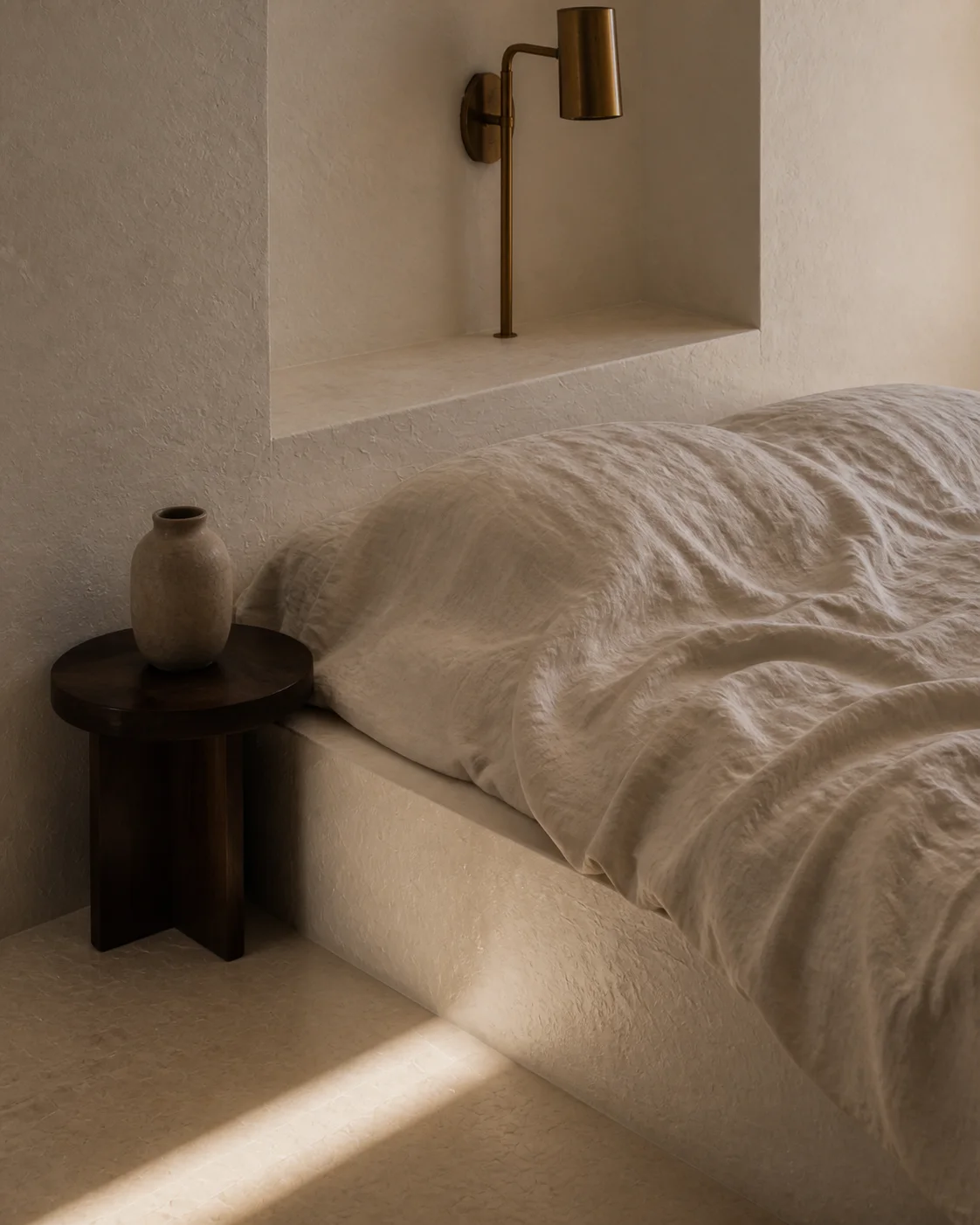 Close bedroom detail of layered natural linen chalk plaster and filtered island daylight beside a low bed in the Milos house part of an editorial architecture walkthrough of a view