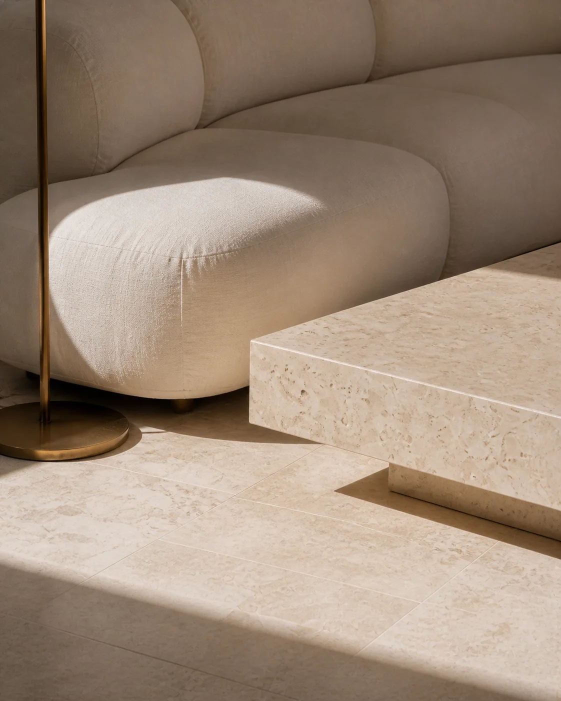Close living room detail with natural linen warm honed limestone smoked oak and chalky lime plaster in hard side light at the Milos house part of an editorial architecture view sky