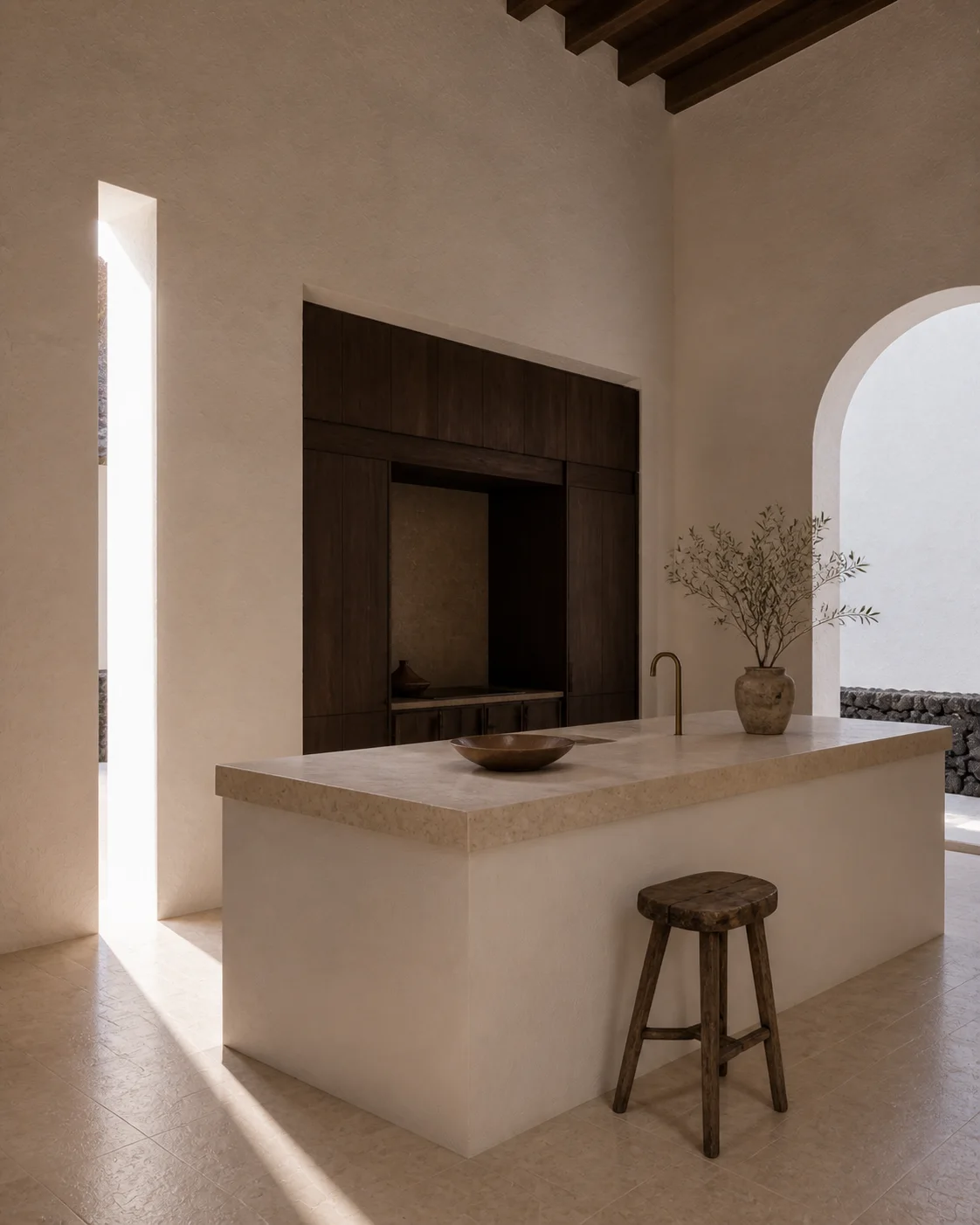 Monolithic lime plaster kitchen in the Milos house with a sculptural island honed limestone smoked oak cabinetry handmade objects and directional daylight part of an editorial view