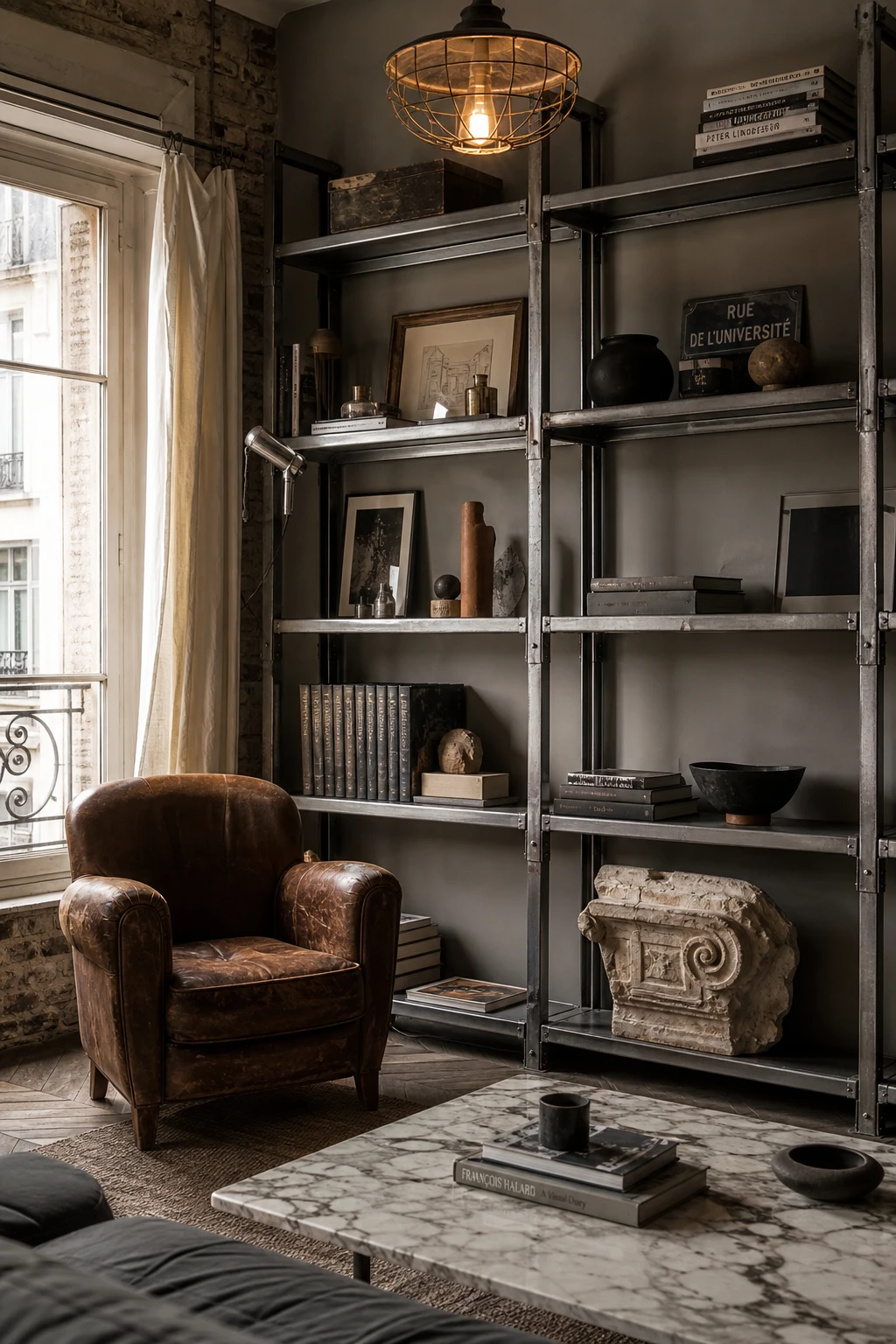 Cozy Parisian living room with industrial French edge featuring exposed steel shelving, raw concrete, warm neutral walls and vintage leather seating in soft afternoon light