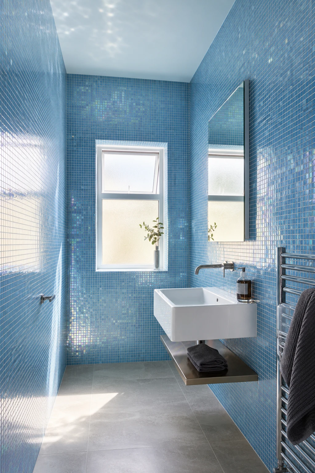 Small blue mosaic tile bathroom with glass tile reflections amplifying natural light, floor to ceiling shimmer, Farrow and Ball Skylight painted walls