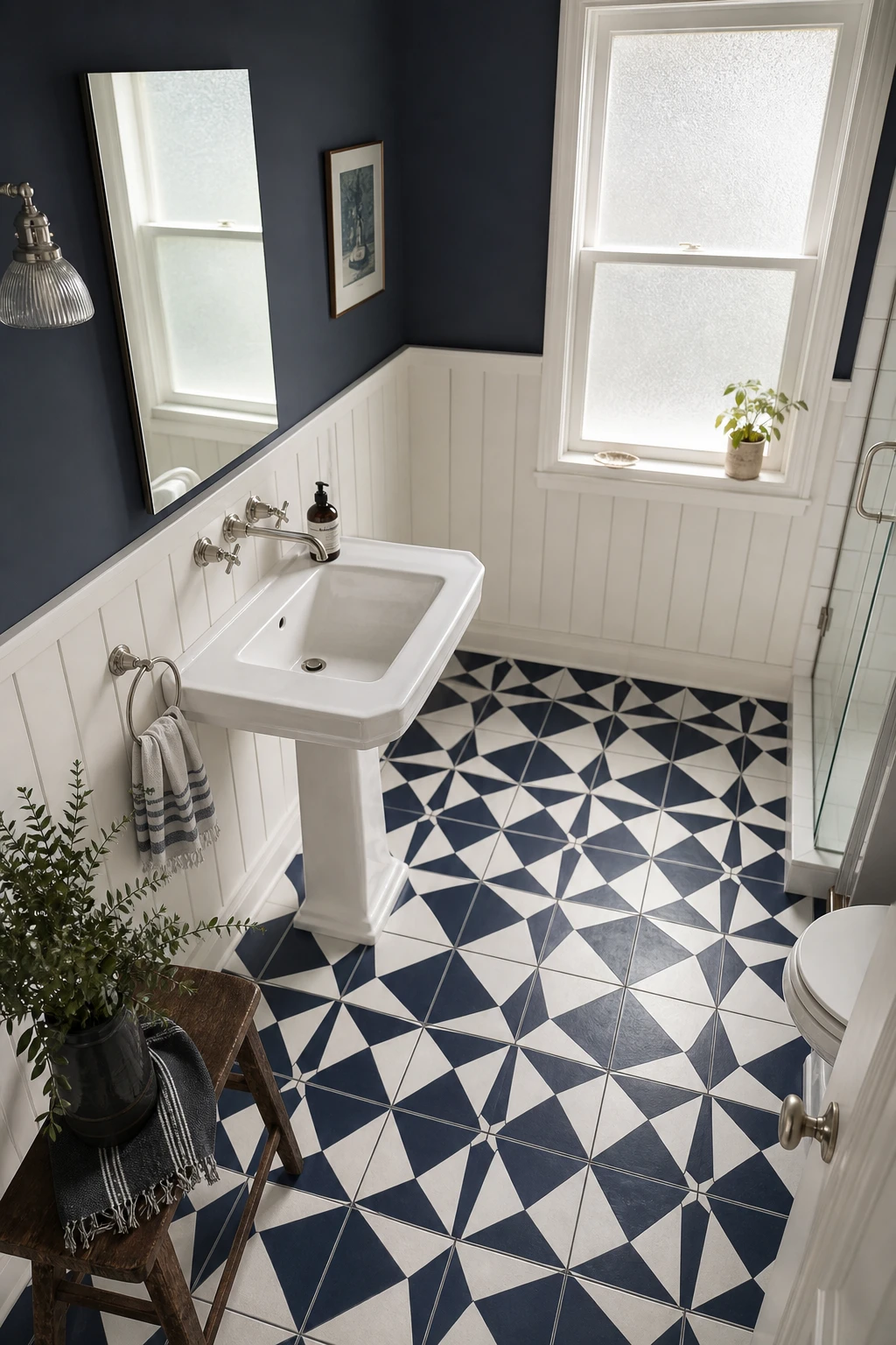 Small navy and white bathroom with bold patterned floor tiles as the hero, white walls in Farrow and Ball Wevet paint, pedestal sink and vintage fixtures