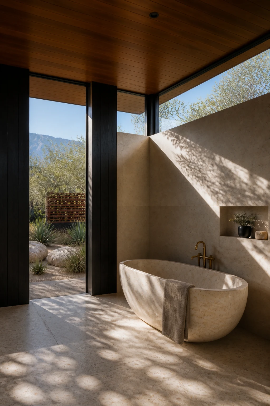 The same pale stone bath beneath timber ceiling and clerestory glass, looking into the olive and agave garden.