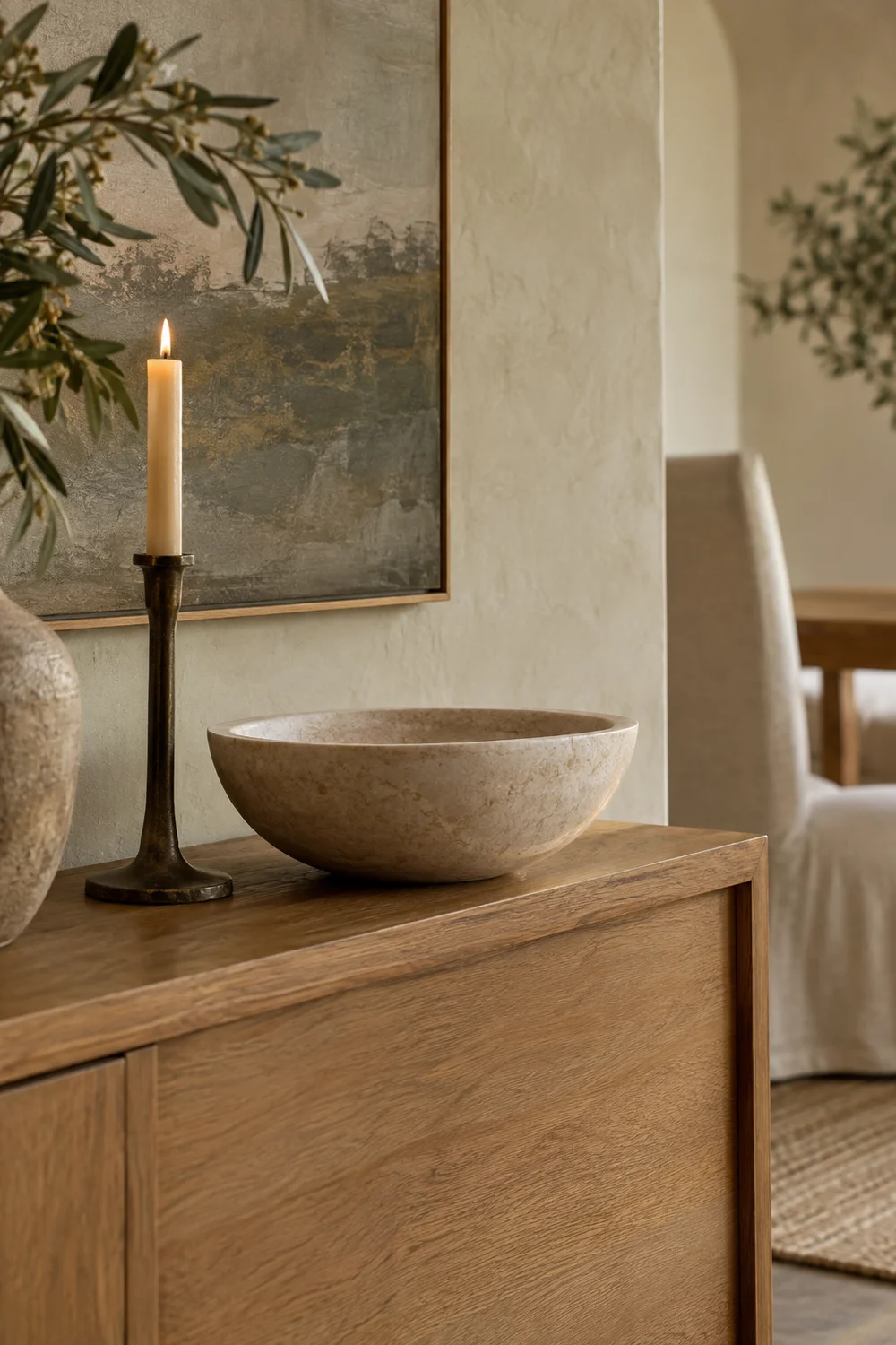 Stone bowl and bronze candlestick on oak sideboard.