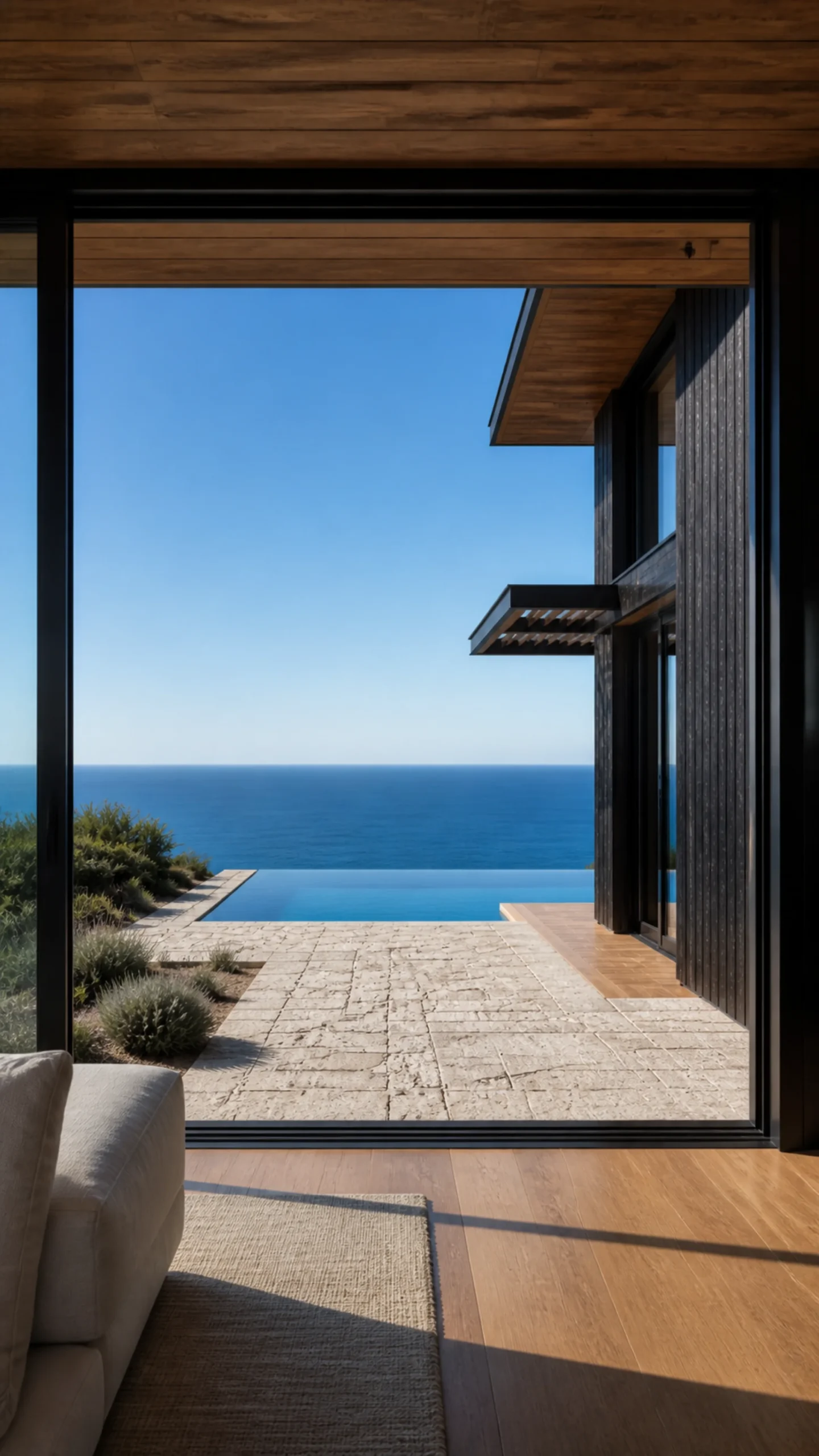 Living room opening through black framed glass to the rear infinity pool and Aegean An original fictional editorial architecture study of material landscape light and spatial view.