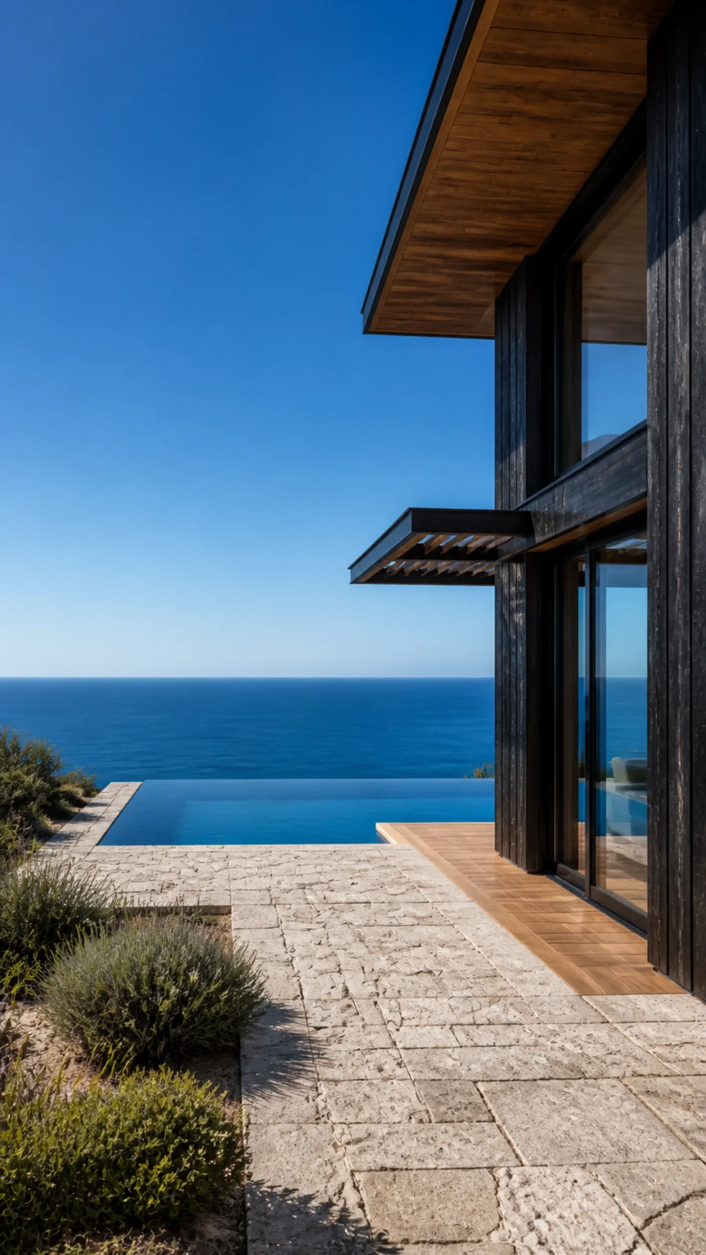 Rear ocean terrace infinity pool directly beyond the black cedar house facing the Aegean An original fictional editorial architecture study of material landscape light and spatial.