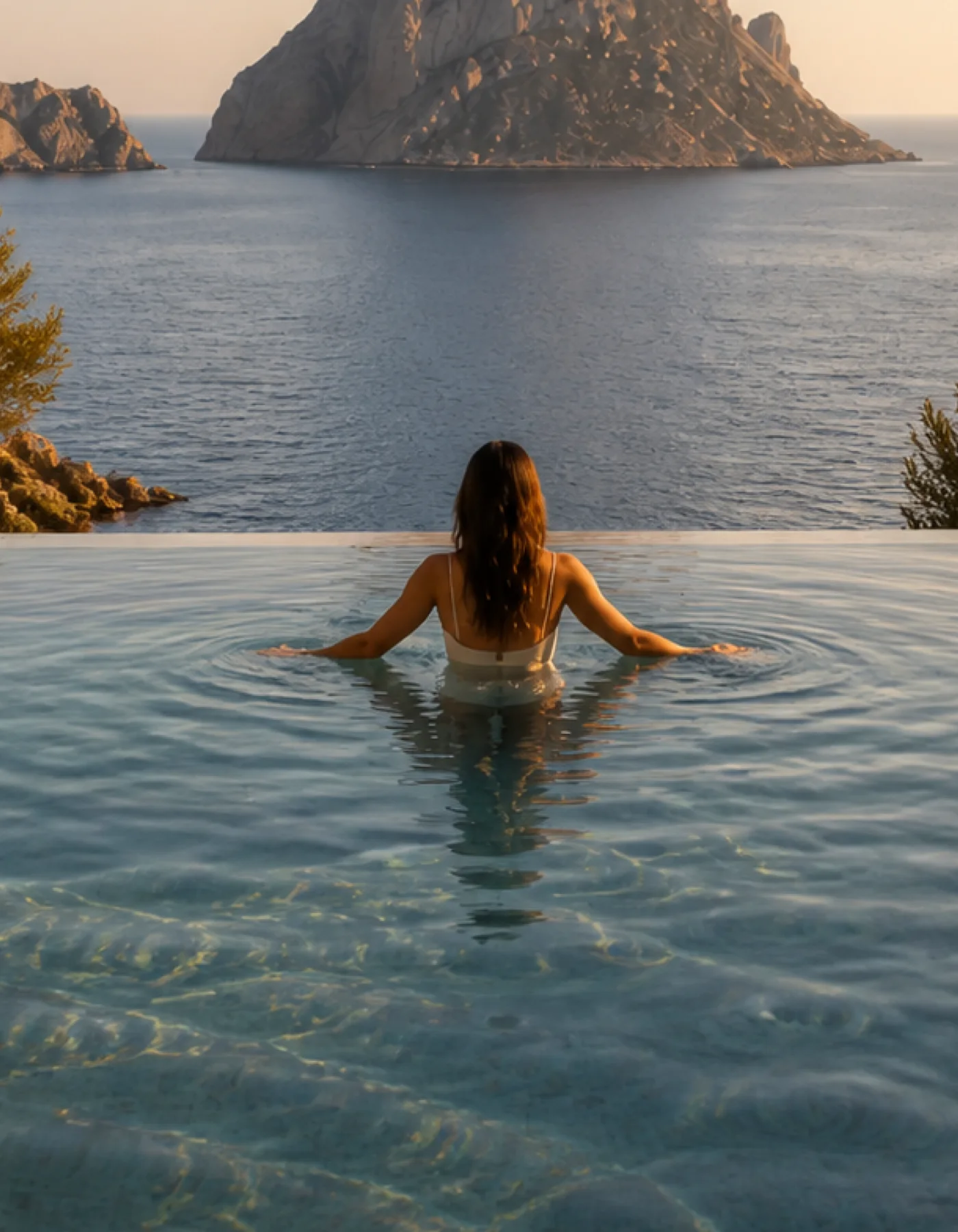 Close clear pool water and pale limestone detail at the Cala d’Hort house in late golden afternoon light. This original fictional Cala d’Hort architecture study records material,..