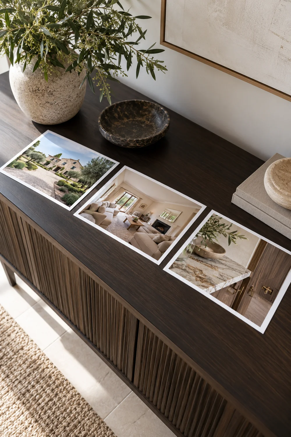 Three property photographs arranged along a timber console